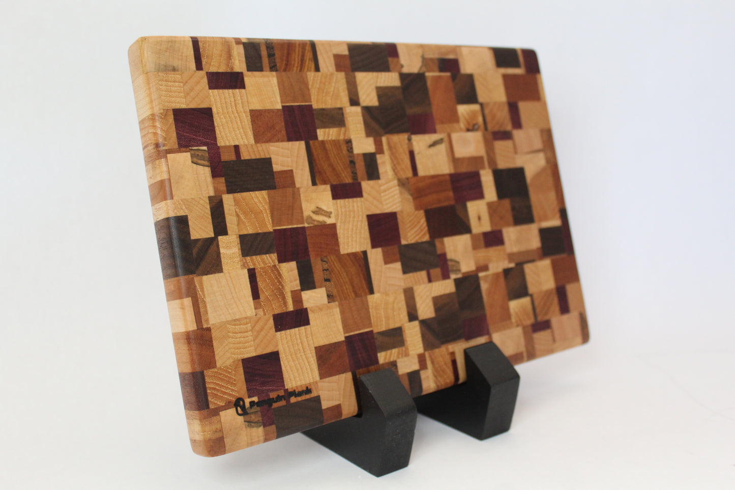 Wooden cutting board with a checkered pattern on a stand against a white background