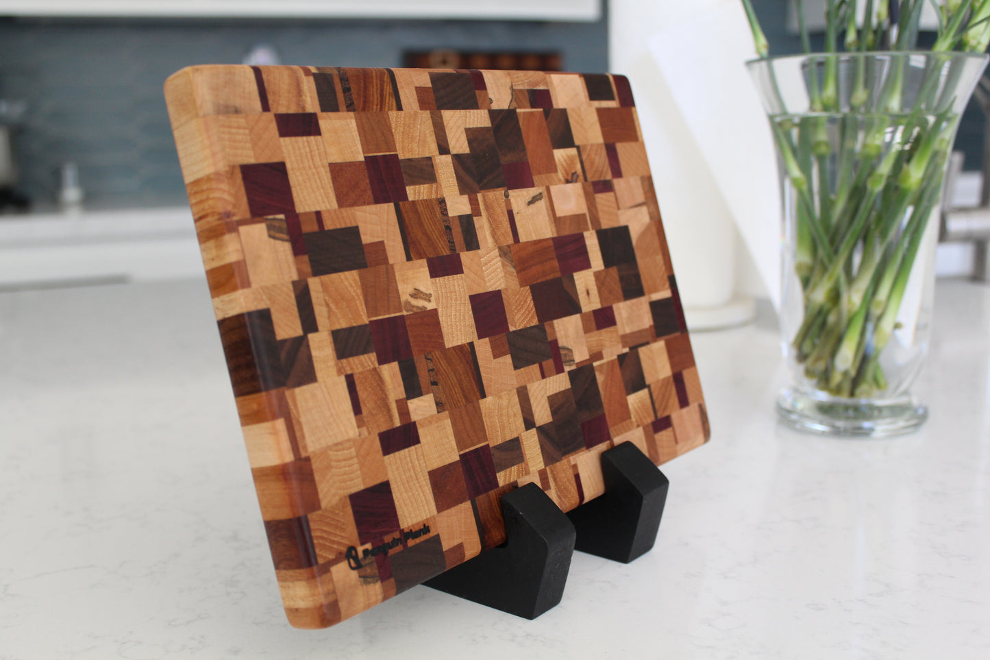 Wooden cutting board with geometric pattern on a stand in a kitchen setting