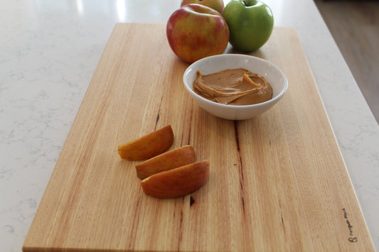 Hickory cutting board with apples and peanut butter.