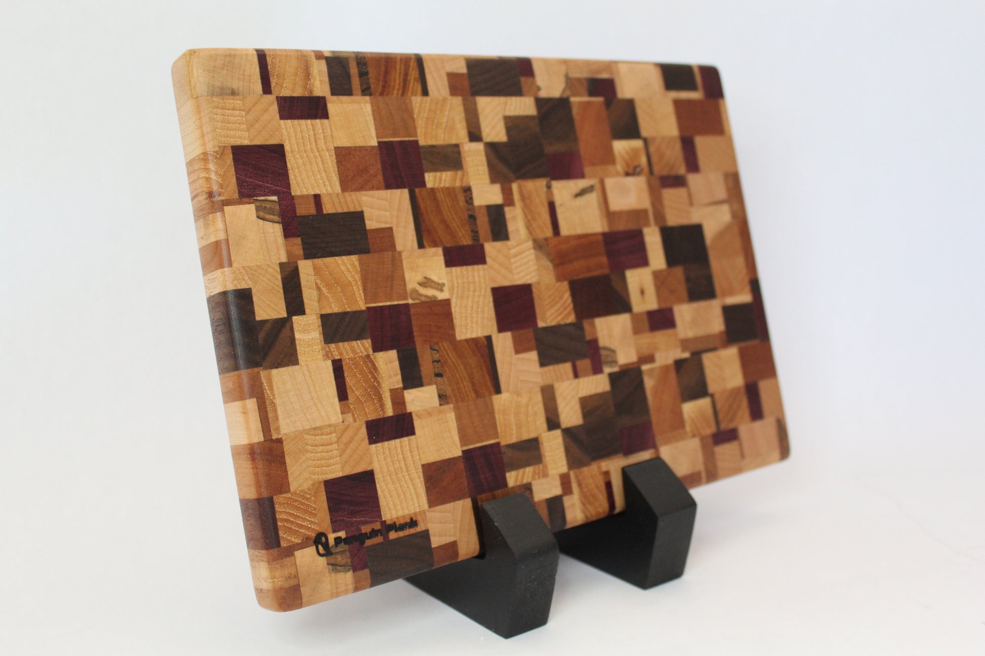Wooden cutting board with a checkered pattern on a stand against a white background