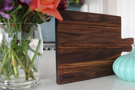 Walnut and zebrawood cheeseboard with handle.